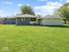Home exterior with a detached garage overlooking an expansive backyard with green grass at 2233 S Miller Ave, Shelbyville, IN 46176
