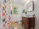 Bathroom featuring a wooden vanity, colorful shower curtain, and bright yellow window trim at 2233 S Miller Ave, Shelbyville, IN 46176