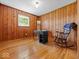 Bedroom with paneled walls, wood floors, natural light and a rocking chair at 2233 S Miller Ave, Shelbyville, IN 46176