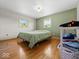 Bedroom with hardwood floors, two windows, and light green accent wall at 2233 S Miller Ave, Shelbyville, IN 46176