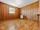 Cozy bedroom with wood paneled walls, wood floors, and a bright window at 2233 S Miller Ave, Shelbyville, IN 46176