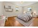 Light-filled bedroom with hardwood floors, two windows, and stylish grey furnishings at 2233 S Miller Ave, Shelbyville, IN 46176