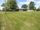 Home and yard featuring an expansive lawn, mature trees, and a neatly maintained fence line at 2233 S Miller Ave, Shelbyville, IN 46176