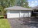 Detached two-car garage with white doors and gray roof next to well maintained home at 2233 S Miller Ave, Shelbyville, IN 46176