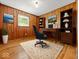 Office space featuring wood paneling, a desk, shelving, and hardwood floors at 2233 S Miller Ave, Shelbyville, IN 46176