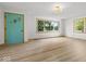 Spacious living room featuring large windows, wood-look floors, and a colorful door at 2233 S Miller Ave, Shelbyville, IN 46176