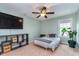This bedroom features a ceiling fan, a television, neutral walls and carpet, and a leafy potted plant at 2436 Gwinnett St, Carmel, IN 46032