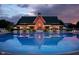 Evening view of the community clubhouse and pool area with lights reflecting in the calm water at 2436 Gwinnett St, Carmel, IN 46032