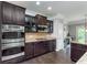 Gourmet kitchen with stainless appliances, granite countertops and dark wood cabinetry at 2436 Gwinnett St, Carmel, IN 46032