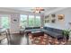 Sun-filled living room with large windows, ceiling fan and unique wall art at 2436 Gwinnett St, Carmel, IN 46032
