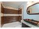 Stylish bathroom featuring a vessel sink, granite countertop, tiled walls, and tub with shower at 2519 N Boehning St, Indianapolis, IN 46219