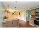 Inviting kitchen and dining area featuring a granite island, wood floors, and stylish pendant lighting at 2519 N Boehning St, Indianapolis, IN 46219