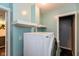Well-lit laundry room with painted walls and white front load washer and dryer, complemented by custom shelving at 2519 N Boehning St, Indianapolis, IN 46219