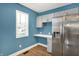 Modern kitchen features stainless steel refrigerator, gray cabinetry, and bright countertops at 2936 N Gladstone Ave, Indianapolis, IN 46218