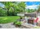 An inviting backyard deck area with outdoor seating surrounded by green space and plants at 332 Campus Ln, Indianapolis, IN 46219