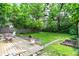 Lush backyard with a wooden deck, a well-maintained lawn, and mature trees for privacy at 332 Campus Ln, Indianapolis, IN 46219