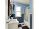 Charming blue bathroom featuring a vanity, a mirror, and a shower-tub combination at 332 Campus Ln, Indianapolis, IN 46219