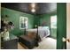 Intriguing bedroom featuring green walls, unique ceiling design, and a comfortable queen-size bed at 332 Campus Ln, Indianapolis, IN 46219