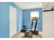 Bright blue exercise room equipped with a treadmill and stationary bike for in-home workouts at 332 Campus Ln, Indianapolis, IN 46219