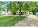 Attractive home with a well-maintained lawn, mature trees, and a gravel driveway at 332 Campus Ln, Indianapolis, IN 46219