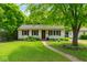 Charming single-story home with a well-manicured lawn, mature trees, and a welcoming walkway at 332 Campus Ln, Indianapolis, IN 46219
