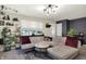 Charming living room with a cozy sectional sofa, stylish decor, and lots of plants at 332 Campus Ln, Indianapolis, IN 46219