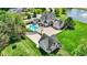 Overhead shot displays a home with a pool, basketball court, outbuilding, and picturesque pond at 3398 Nottinghill Blvd, Plainfield, IN 46168