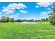 Lush green field showcases a serene pond with a fountain and surrounding trees at 3398 Nottinghill Blvd, Plainfield, IN 46168