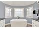 Bathroom with freestanding tub, gray walls, and transom windows that allow in natural light at 3398 Nottinghill Blvd, Plainfield, IN 46168