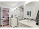 Bathroom with double sinks, mosaic backsplash, and open doorway to a bedroom at 3398 Nottinghill Blvd, Plainfield, IN 46168