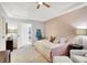bedroom with pale hardwood floors, decorated walls, and an open doorway to a bathroom at 3398 Nottinghill Blvd, Plainfield, IN 46168