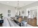Traditional dining room with modern chandelier, table with six chairs and bench and large window at 3398 Nottinghill Blvd, Plainfield, IN 46168