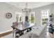 Traditional dining room with modern chandelier, table with six chairs and bench, and a clock hanging on the wall at 3398 Nottinghill Blvd, Plainfield, IN 46168