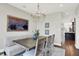 Traditional dining room with modern chandelier, table with six chairs and bench, and hardwood flooring at 3398 Nottinghill Blvd, Plainfield, IN 46168