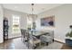 Traditional dining room with modern chandelier, table with six chairs and bench, and a large window at 3398 Nottinghill Blvd, Plainfield, IN 46168