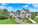 Stunning two-story brick home featuring a circular driveway, lush landscaping, and porte-cochère at 3398 Nottinghill Blvd, Plainfield, IN 46168