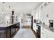 Open kitchen with granite countertops, stainless steel appliances, dark island, and beautiful hardwood floors at 3398 Nottinghill Blvd, Plainfield, IN 46168