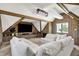 Cozy living room featuring a built-in TV console, exposed beams, wood paneling, and an expansive sectional sofa at 3398 Nottinghill Blvd, Plainfield, IN 46168