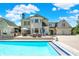 A beautiful inground pool is surrounded by a travertine patio and an outdoor kitchen and seating area at 3398 Nottinghill Blvd, Plainfield, IN 46168