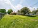 Expansive backyard with lush green grass, trampoline, and mature trees at 3538 Whalen Ave, Indianapolis, IN 46227
