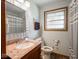 Bathroom featuring a sink vanity, toilet, window, and walk-in shower with curtain at 3538 Whalen Ave, Indianapolis, IN 46227
