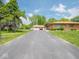 Brick home with a long driveway and a detached two car garage, complemented by a green lawn at 3538 Whalen Ave, Indianapolis, IN 46227