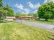 Brick home with a long driveway and detached garage, surrounded by a well-kept lawn and trees at 3538 Whalen Ave, Indianapolis, IN 46227