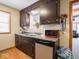 Functional kitchen space with dark cabinetry, stainless steel dishwasher, and a view into the living area at 3538 Whalen Ave, Indianapolis, IN 46227