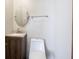 Simple half bath featuring a round mirror, single vanity, and toilet against a neutral wall at 3538 Whalen Ave, Indianapolis, IN 46227