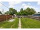 Manicured backyard features a grassy lawn, wooden fence, raised garden bed, and stepping stone pathway at 3916 E 10Th St, Indianapolis, IN 46201