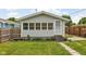 Front exterior featuring gray siding, a screen door and a well kept lawn with garden at 3916 E 10Th St, Indianapolis, IN 46201