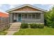 Charming home featuring a covered front porch with painted brick pillars and a vibrant turquoise storm door at 3916 E 10Th St, Indianapolis, IN 46201