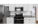 Stainless steel kitchen range and microwave with white cabinets and granite countertops at 3916 E 10Th St, Indianapolis, IN 46201