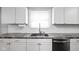 Close up of the stainless steel sink with a white tile backsplash and granite countertops at 3916 E 10Th St, Indianapolis, IN 46201